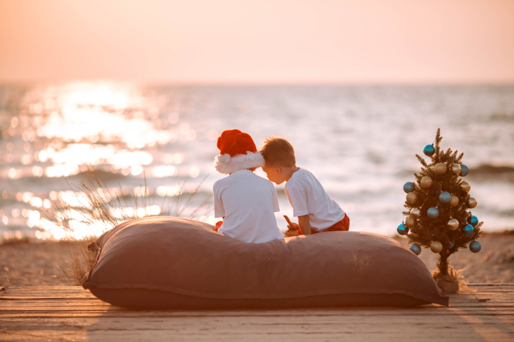 Två barn sitter på en strand